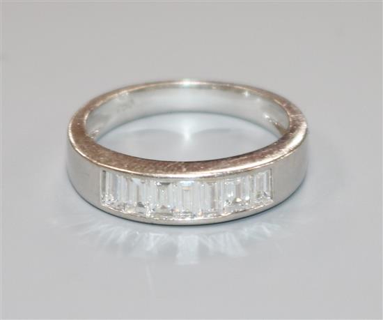 An 18ct white gold and seven stone channel set diamond half hoop ring, size N.